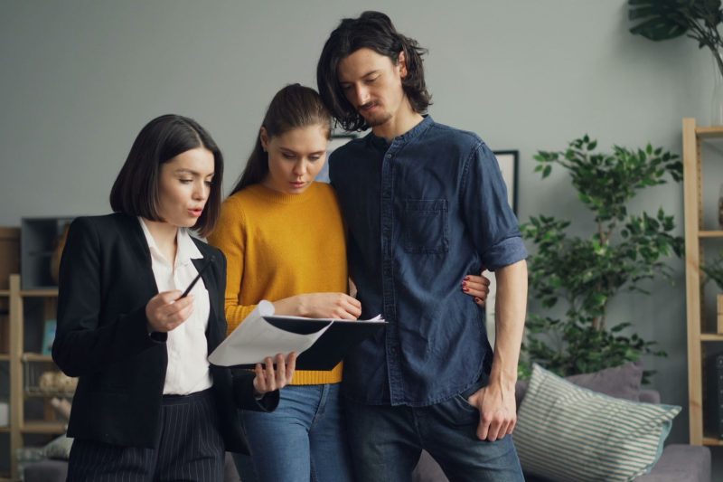 Home 145 A couple reviewing documents with a real estate agent indoor 1781629493